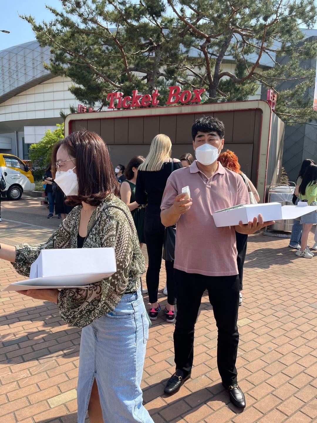 Hình ảnh bố mẹ GOT7 đứng phát bánh gạo cho fan trong khu vực tổ chức concert (1)