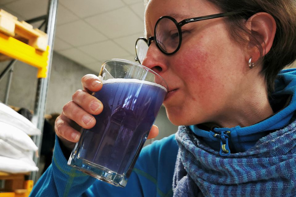 Công nhân Mathilde Vanmansart thưởng thức một ly bia xanh lam (Ảnh: Reuters)