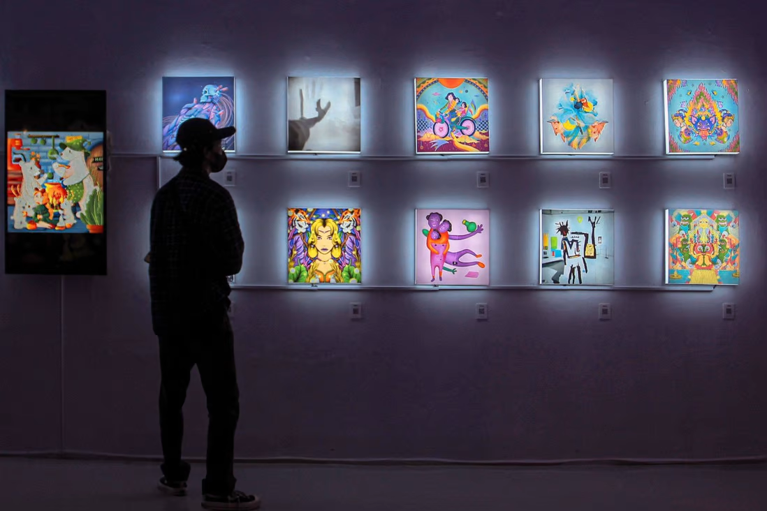 Một du khách quan sát các tác phẩm của NFT tại một cuộc triển lãm ở Yogyakarta, Indonesia. Một ...