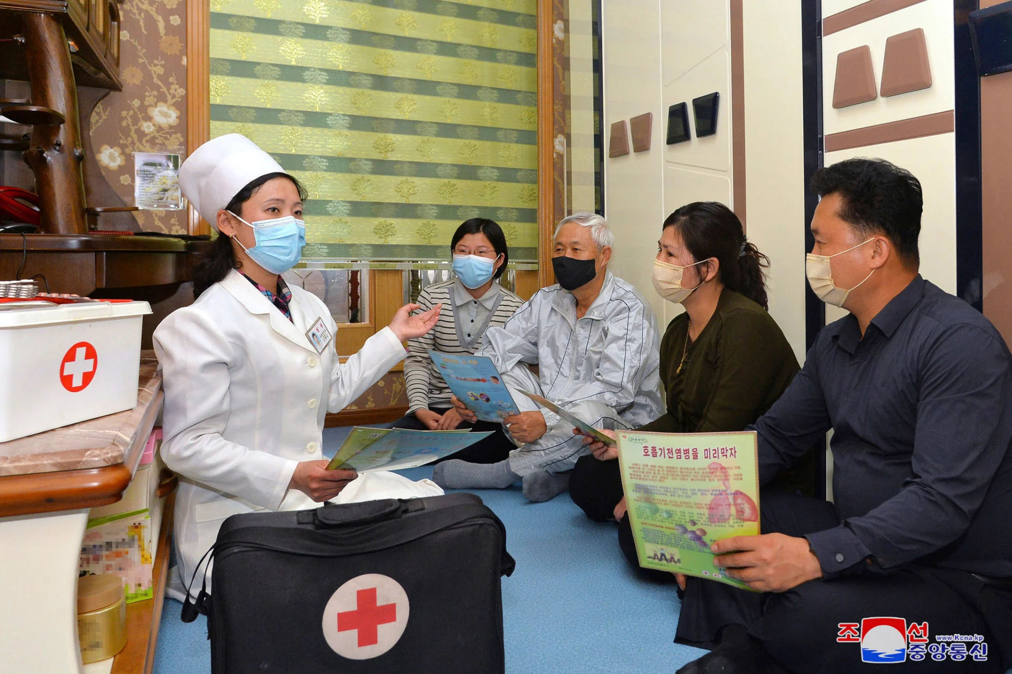 Một nhân viên y tế nói chuyện với một gia đình về các biện pháp phòng chống Covid-19 vào thứ Ba trong bức ảnh này do chính phủ Triều Tiên cung cấp. 