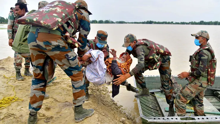Các binh sĩ quân đội sơ tán một dân làng bị ảnh hưởng bởi lũ lụt sau trận mưa lớn ở quận Hojai, ...
