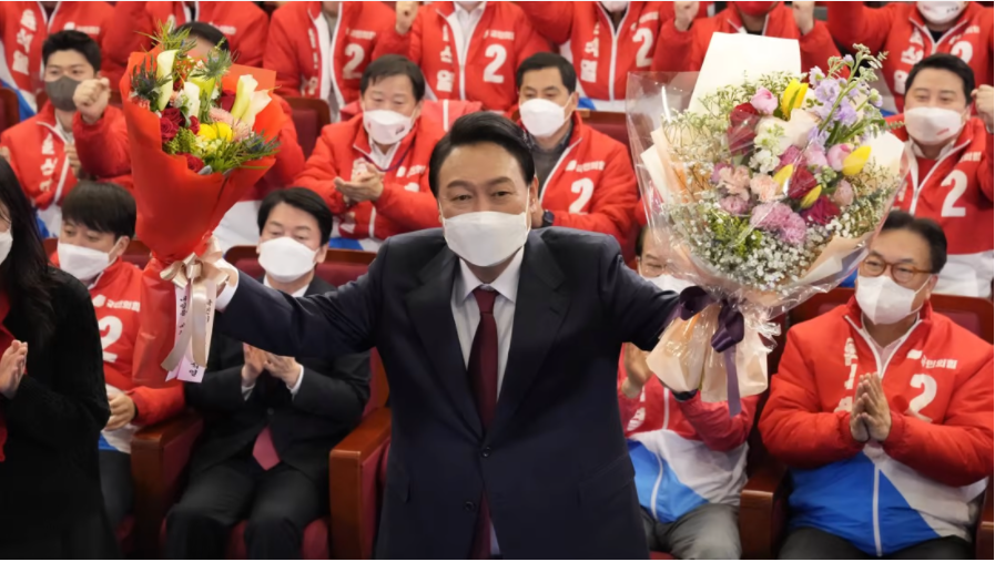  Tổng thống đắc cử Hàn Quốc Yoon Suk-yeol cầm bó hoa khi ông được các đảng viên và các nhà lập ...